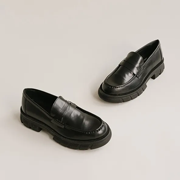 Moccasins with notched soles in glazed black leather