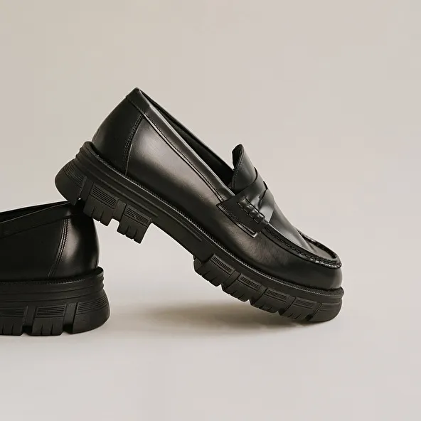 Moccasins with notched soles in glazed black leather